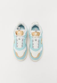 Blå och vita sneakers med mesh- och lädermaterial, guldaccenter och en vadderad krage. Snören och logotypen visas på tungan.