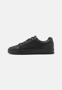 Black sneaker with a smooth leather upper, featuring a textured panel, round toe, and flat rubber sole. Laces and subtle logo detail present.
