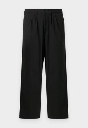 Black pleated trousers made of cotton, featuring a relaxed fit, a button closure, and side pockets. No visible patterns or hardware details.