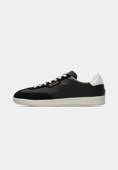Baskets en cuir noir avec des accents blancs, des panneaux texturés et une semelle en caoutchouc lisse. Présentent un logo bien visible sur le côté et un laçage classique.