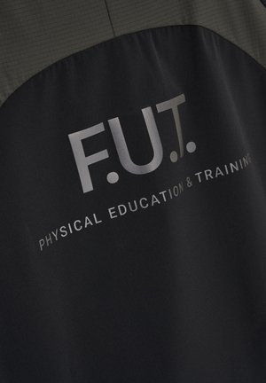 Close-up van de achterkant van een zwart-grijs jack met de opdruk "F.U.T. Physical Education & Training" in lichtgrijze letters.