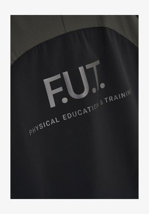 Close-up van de achterkant van een zwart-grijs jack met de opdruk "F.U.T. Physical Education & Training" in lichtgrijze letters.