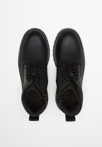 Schwarze Lederstiefeletten mit glattem Finish, runder Zehenpartie und Schnürdesign. Verfügt über eine kontrastierende, strukturierte Gummisohle und einen seitlichen Reißverschluss.