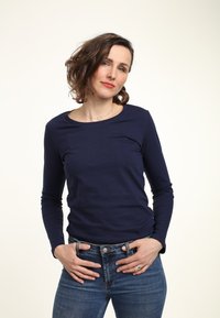 Granatowa koszula z długim rękawem, wykonana z bawełny, z okrągłym dekoltem. Połączona z nieco niebieskimi dżinsami, o klasycznym kroju i niewielkiej elastyczności.