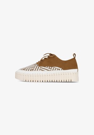 Zapatilla de cordones en ante marrón con un patrón de zigzag blanco, que presenta una gruesa suela de plataforma estriada y una lengüeta trasera.
