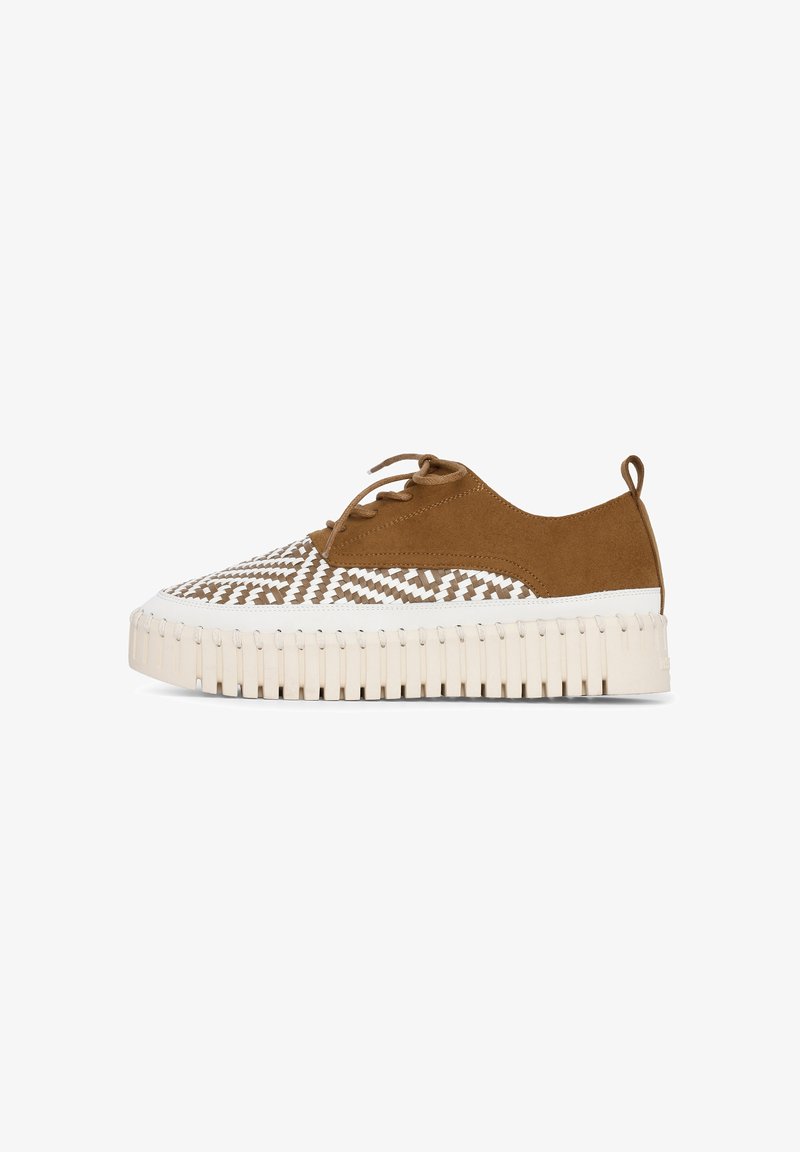 Lace-up sneaker in brown suede with a white zigzag pattern, featuring a thick ribbed platform sole and a back pull tab.
