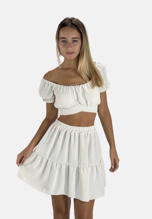 Zweiteiliges Outfit, bestehend aus einem kürzeren, schulterfreien Oberteil und einem ausgestellten, gestuften Rock. Hergestellt aus einem leichten, strukturierten, hellen Creme-Stoff.