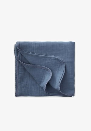 Tissu mousseline bleu doux plié avec un coin retourné, présentant une bordure délicatement cousue sur un fond blanc.