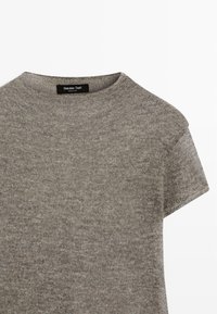 Grijze korte mouw gebreide trui met een ronde hals en licht verlaagde schoudernaden. Label zichtbaar met merknaam "Massimo Dutti."