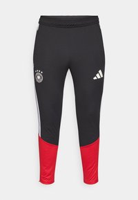 Schwarze Sporthose mit roten unteren Akzenten, weißen Seitenstreifen, einem runden Logo und vier Sternen am linken Oberschenkel. Hergestellt aus dehnbarem Material.