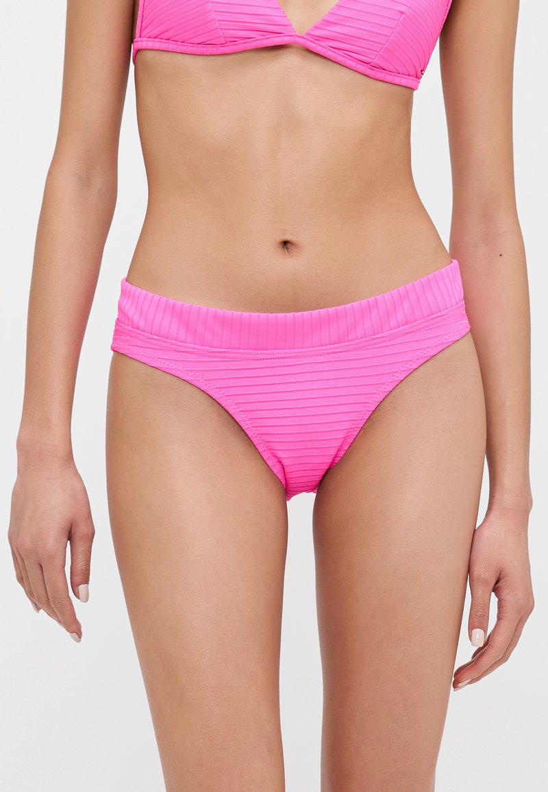 Rózsaszín bikini alsó, bordázott textúrával, széles derékrésszel és alacsony szabással. Egyszínű, minta vagy díszítés nélkül.