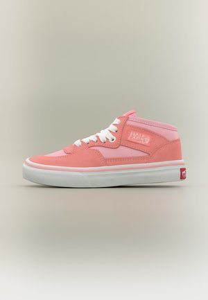 Baskets montantes roses avec lacets blancs, semelle blanche et étiquette « Half Cab » sur le côté, sur un fond neutre uni.