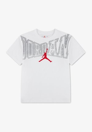 Tee-shirt blanc avec grand texte « "JORDAN" » en contours et un logo de basket Jumpman rouge centré sur la poitrine. Aucune personne visible.