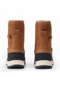Bruine suede enkellaarzen met een tan leren band, rubberen zool en een crème kleurige tussenzool. Voorzien van een gestructureerd accent bij de achterkant.