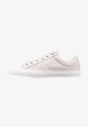 Sneaker beige chiaro low-top con suola in gomma bianca, logo a stella sul lato e chiusura con lacci.