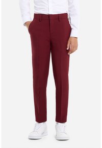 Pantalones tailored burdeos con un tejido suave, diseño de pierna recta y bolsillos laterales, combinados con zapatillas blancas.