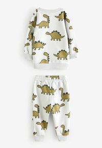 Hvidt todelt børnetøj bestående af en sweatshirt og bukser, begge med gyldne dinosaurtryk, ribbede manchetter og elastisk talje.