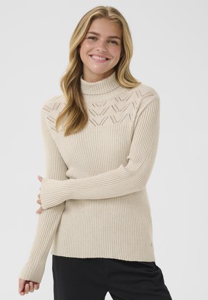 Beige ribstrik turtleneck sweater med et struktureret strikkemønster ved skuldrene og lange ærmer, der har tommelfingerhuller.