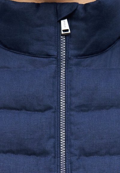 Μπουφάν σε ναυτικό μπλε με επένδυση και κεντρικό ασημί φερμουάρ με την επιγραφή "POLO", που δείχνει κοντινές λεπτομέρειες του υφάσματος και της ραφής.