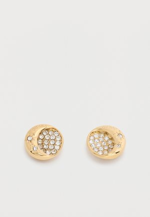 Orecchini a perno rotondi in tono oro con cristalli trasparenti e piccoli motivi floreali, con il marchio "GUESS" sul bordo.