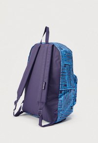 Modrý a černý vzorovaný batoh s jednobarevnými tmavě modrými polstrovanými popruhy a horním úchopem, zobrazený zezadu na jednobarevném pozadí.