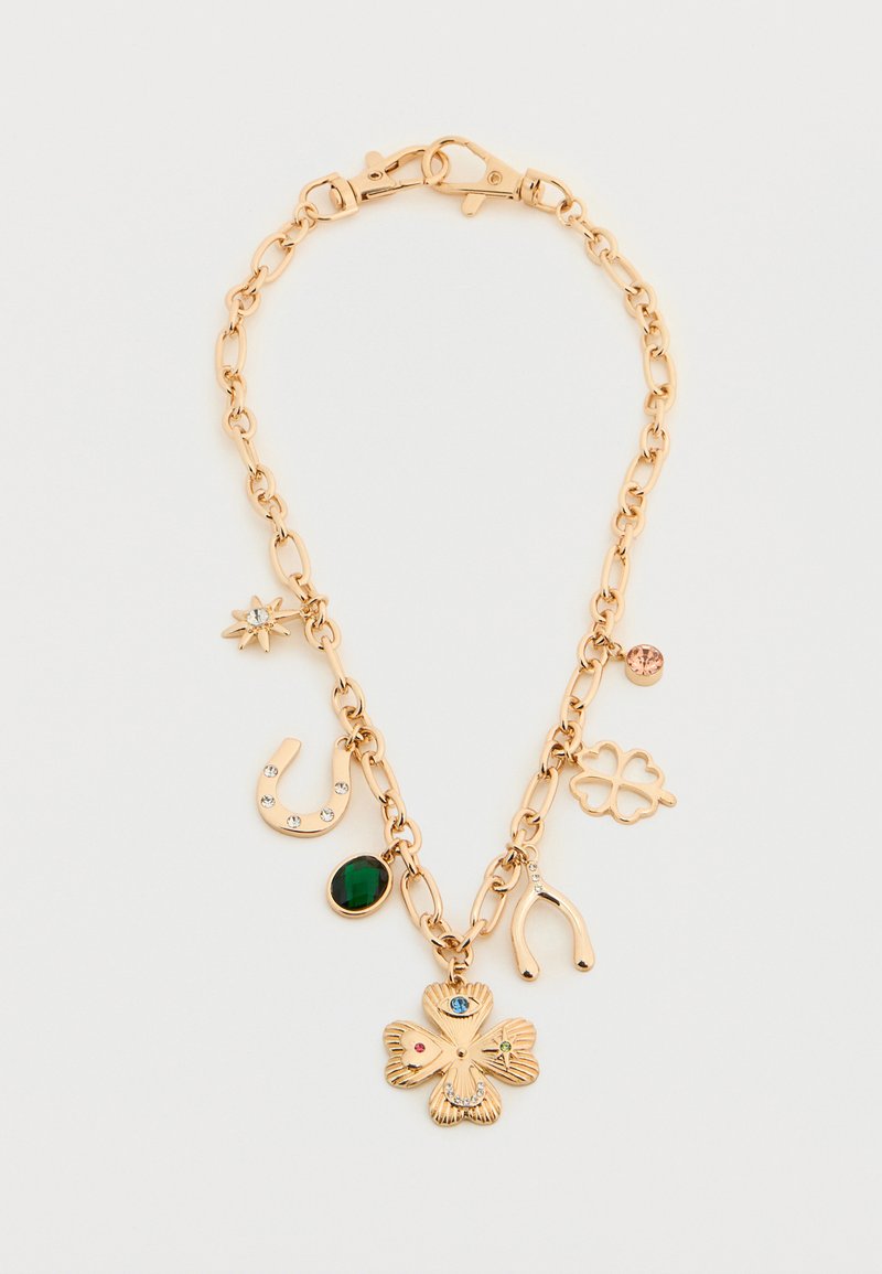Le bracelet à chaîne dorée présente des breloques, y compris un trèfle à quatre feuilles, un fer à cheval et des accents de pierres précieuses en vert et rose.