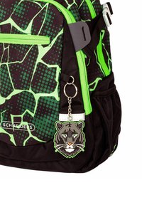 Zwarte en groene rugzak met een geometrisch patroon, felgroene ritsen en een sleutelhanger met een tijger als accent. Gemaakt van duurzaam materiaal.