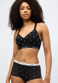 Σετ από μαύρο βαμβακερό σουτιέν bralette και εσώρουχο hipster με επαναλαμβανόμενο μοτίβο λογότυπου «CK». Το bralette διαθέτει ρυθμιζόμενους ιμάντες και ζώνη με λογότυπο.