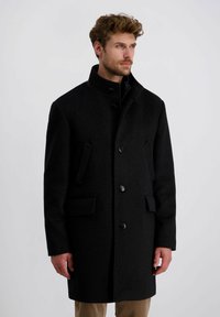 Schwarzer Wollmantel mit hohem Kragen und vorderer Knopfleiste, ausgestattet mit zwei seitlichen Taschen und taillierter Passform. Glatte Textur, klassisches Design.