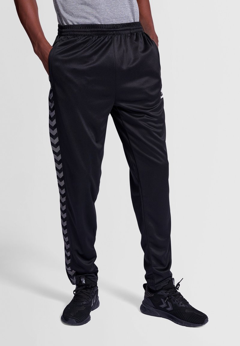 Schwarze Sporthose aus glattem, leichtem Material mit einem Fischgrätmuster an der Seite und einem elastischen Bund.
