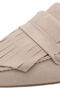 Mocassino in pelle scamosciata beige con dettagli a frange, una larga fascia sulla parte superiore e suola piatta. Presenta dettagli cuciti e una texture morbida.