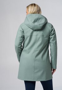 Lichtgroene, waterdichte jas met capuchon; gladde textuur; lange mouwen; naden detail op de rug; knielange uitstraling.