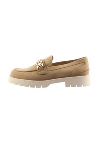 Mocassin en cuir beige avec un accent en chaîne dorée et une semelle blanche épaisse, présentant des lignes épurées et une texture lisse. Conception légère.