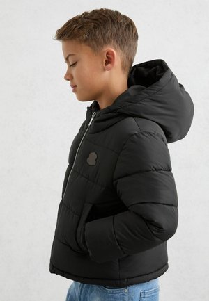 Schwarze Steppjacke mit Kapuze, Reißverschluss und Seitentaschen. Verfügt über ein strukturiertes Logo auf der Brust. Weiches Material mit einem gesteppten Muster.