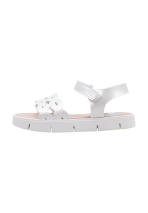 Sandalia blanca con diseño recortado en las correas y correa ajustable en el tobillo, que presenta una gruesa suela blanca y una plantilla rosa.