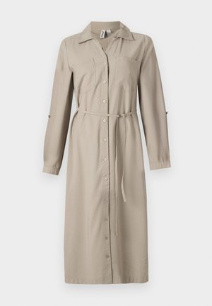 Ilgas, bežinis marškinėlių suknelės stilius su apykakle, priekiniais mygtukais, dviem krūtinės kišenėmis ir juosmens diržu. Rankovės gali būti sukeltos. Minkšta medžiaga.