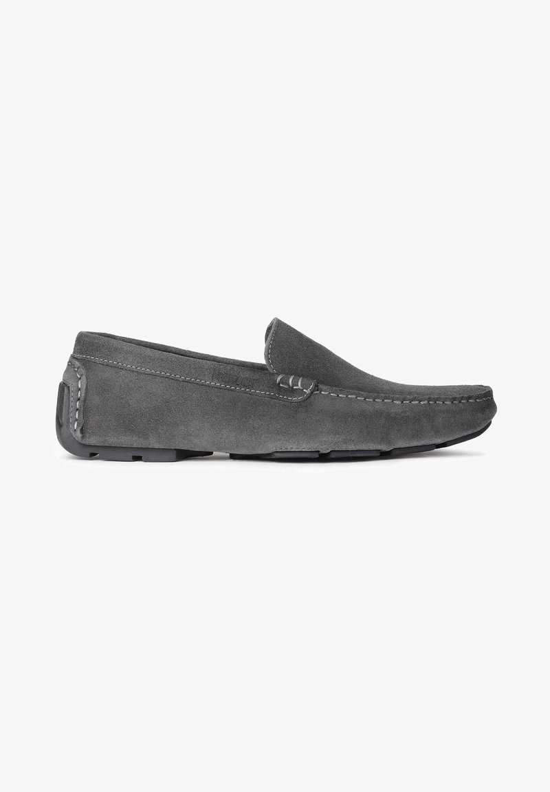 Chaussures grises en daim à enfiler, avec un bout arrondi, des coutures décoratives et une semelle en caoutchouc texturée. Design discret avec des accents minimalistes.