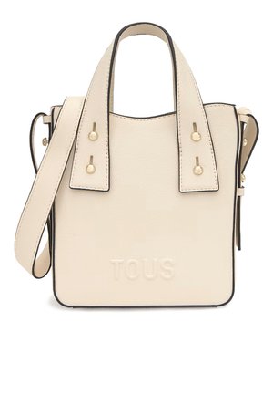 Bolso de mano de cuero color crema con asas dobles, correa de hombro ajustable, herrajes en tono dorado y logotipo "TOUS" en relieve en el frontal.