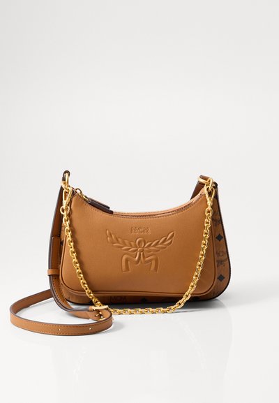 Sac à épaule en cuir brun avec logo en relief, chaîne dorée et sangles en cuir, forme courbée, et accents décoratifs sur les côtés.