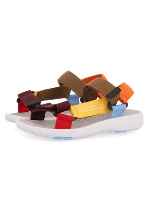 Sandalias de punta abierta con tiras multicolores en rojo, amarillo, marrón, naranja y azul, con suelas acolchadas blancas y cierres ajustables.