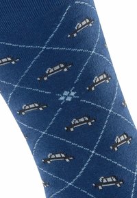 Niebieska skarpetka wykonana z materiału dzianinowego, z powtarzającym się wzorem samochodu obrysowanym białymi diamentami i jasnoniebieskimi liniami na powierzchni.