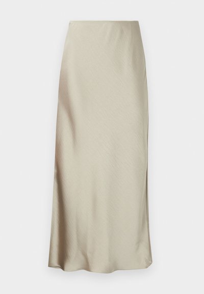 Une longue jupe beige clair en tissu lisse présente une légère brillance et un ourlet évasé, offrant un design épuré et minimaliste.