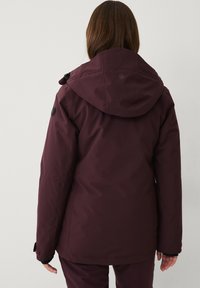 Bordeaux winterjack met capuchon, met een gladde textuur, schouderpatches en elastische manchetten voor warmte en comfort.