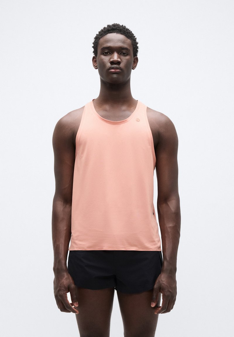 Αμάνικο αθλητικό τοπ σε ανοιχτό ροζ χρώμα, κατασκευασμένο από ελαφρύ ύφασμα, με μίνιμαλ σχεδιασμό και μικρό λογότυπο στο μπροστινό μέρος.