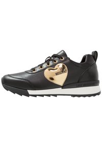 Black sneaker with a smooth leather finish, gold heart accent, white outsole, and black laces. Features a branded logo on the side.