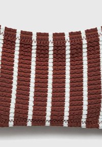 Tessuto a strisce rosse e bianche con una superficie texturizzata e arricciata, caratterizzato da strisce alternate di materiale liscio e arricciato.