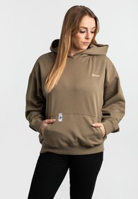 Hoodie i olivgrön, tillverkad av mjukt material, med en känguruficka, ribbade ärmslut och en liten logotyp på bröstet.