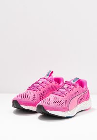 Scarpe sportive rosa con tomaia in mesh traspirante, dettagli testurizzati, suola in gomma nera e intersuola bianca ammortizzata.