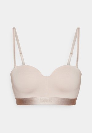 Light beige bra with a smooth, stretchy fabric, scalloped neckline, adjustable straps, and a satin band featuring embossed "BOSS" logo.