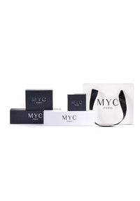 Set di scatole regalo e una borsa per la spesa, realizzate con materiali in bianco e nero, con il marchio "MYC PARIS" in colori a contrasto.
